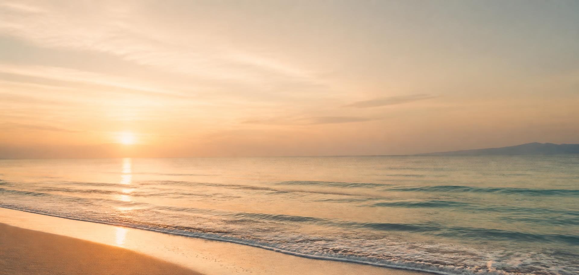 Woman standing at the shoreline with open arms, facing a calm ocean sunrise